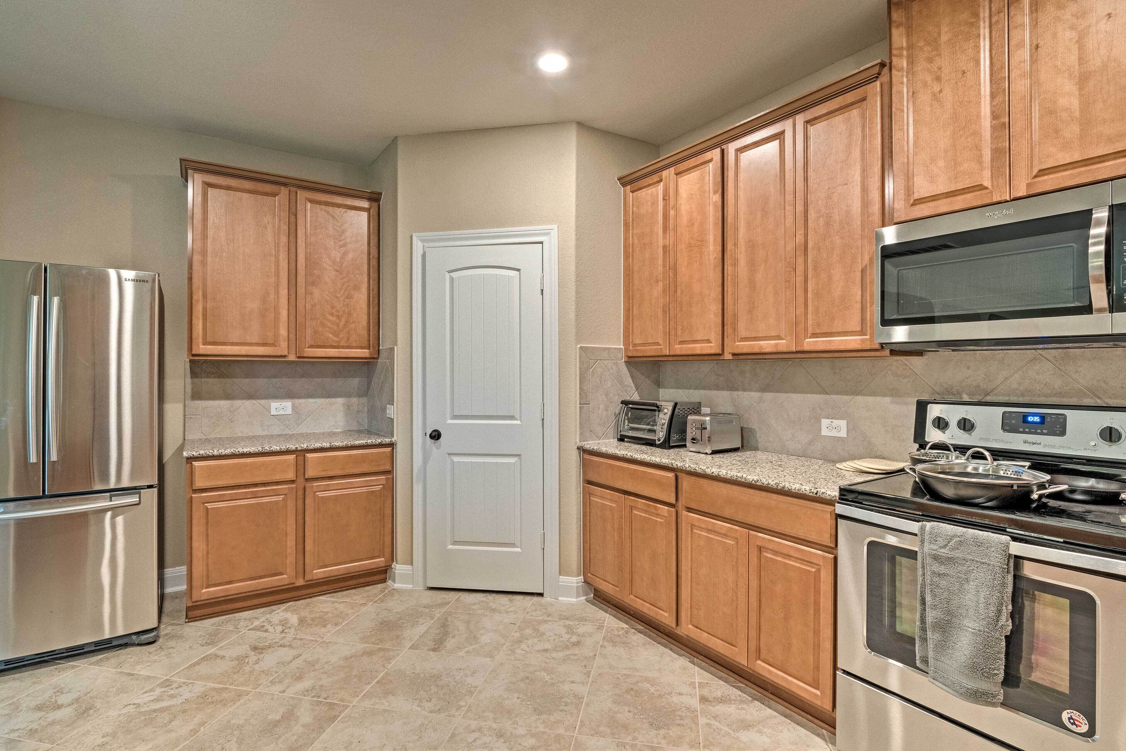 A kitchen with wooden cabinets, stainless steel appliances, a microwave, a toaster, and a stove.