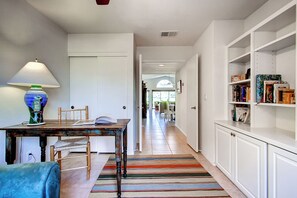 A hallway with a dining area, a bookshelf, and a patterned rug. - Country Club Home: 2br, 2 BA + Den ~ 1 Mi to Golf! (Borrego Springs)