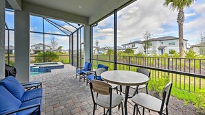 A covered outdoor patio with seating and a view of a residential neighborhood. - Luxury Ave Maria Rental w/ Private Pool & Spa! (Immokalee)