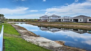 A row of modern houses with a calm water body in the foreground. - Luxury Ave Maria Rental w/ Private Pool & Spa! (Immokalee)