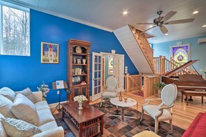 A living room with a blue wall, a piano, a staircase, and a couch. - 16 Mi to Camelback Resort: Getaway w/ Game Room (Brodheadsville)