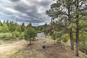A river flowing through a forested area with trees and a camping site. - Quiet Riverside Retreat: Hike, Fish & Ski! (Eureka)