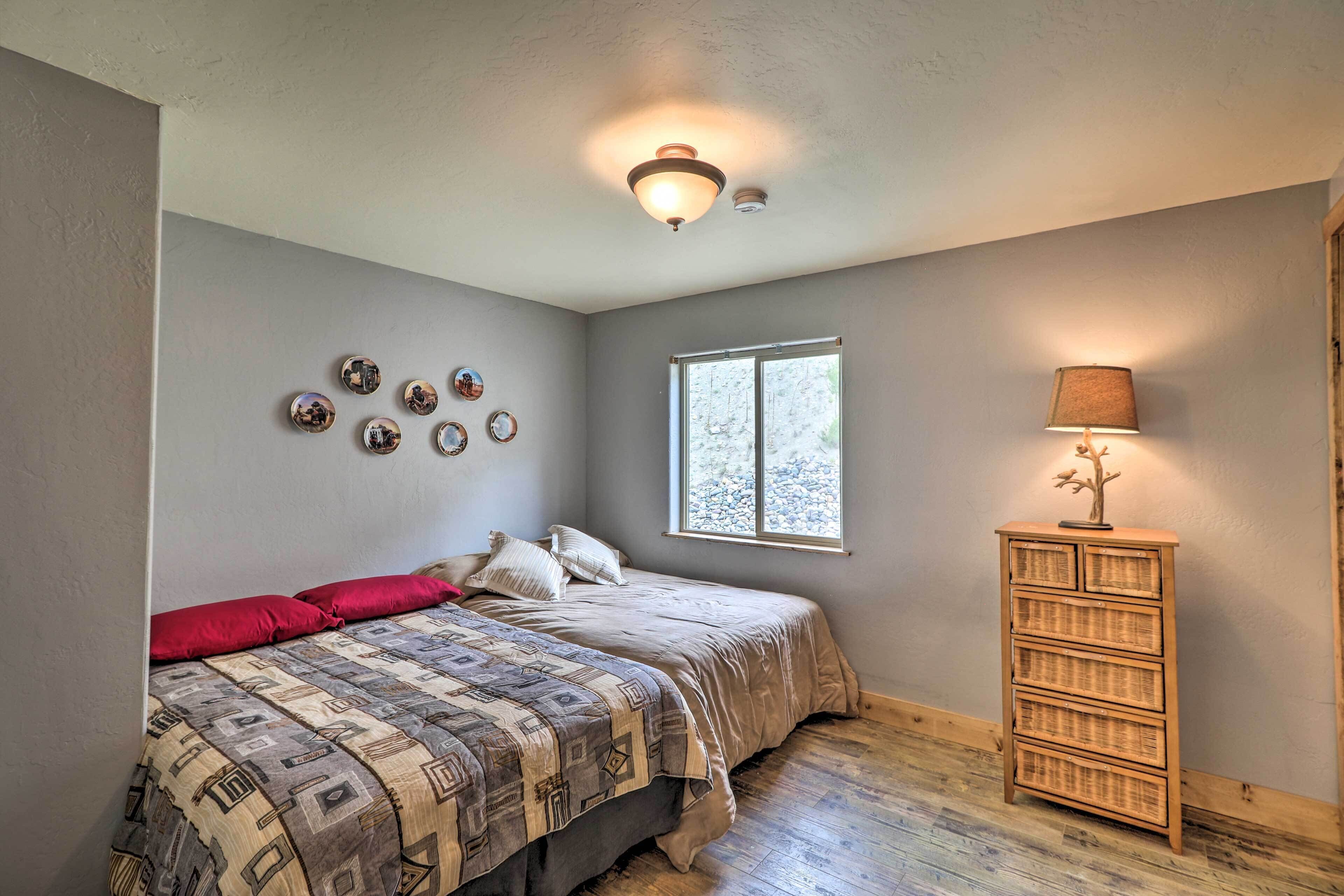 A bedroom with a bed, a dresser, a window, and wall decorations.