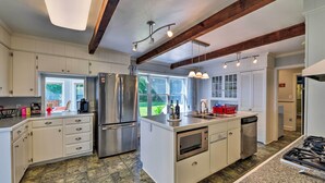 A modern kitchen with white cabinetry, stainless steel appliances, and a large island. - Bayfront Blounts Creek Home: Private Beach + Dock! (Blounts Creek)