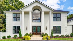A two-story house with a central entrance, symmetrical windows, and a brick facade. - Luxury Maineville Villa w/ Private Pool & Deck (Maineville)