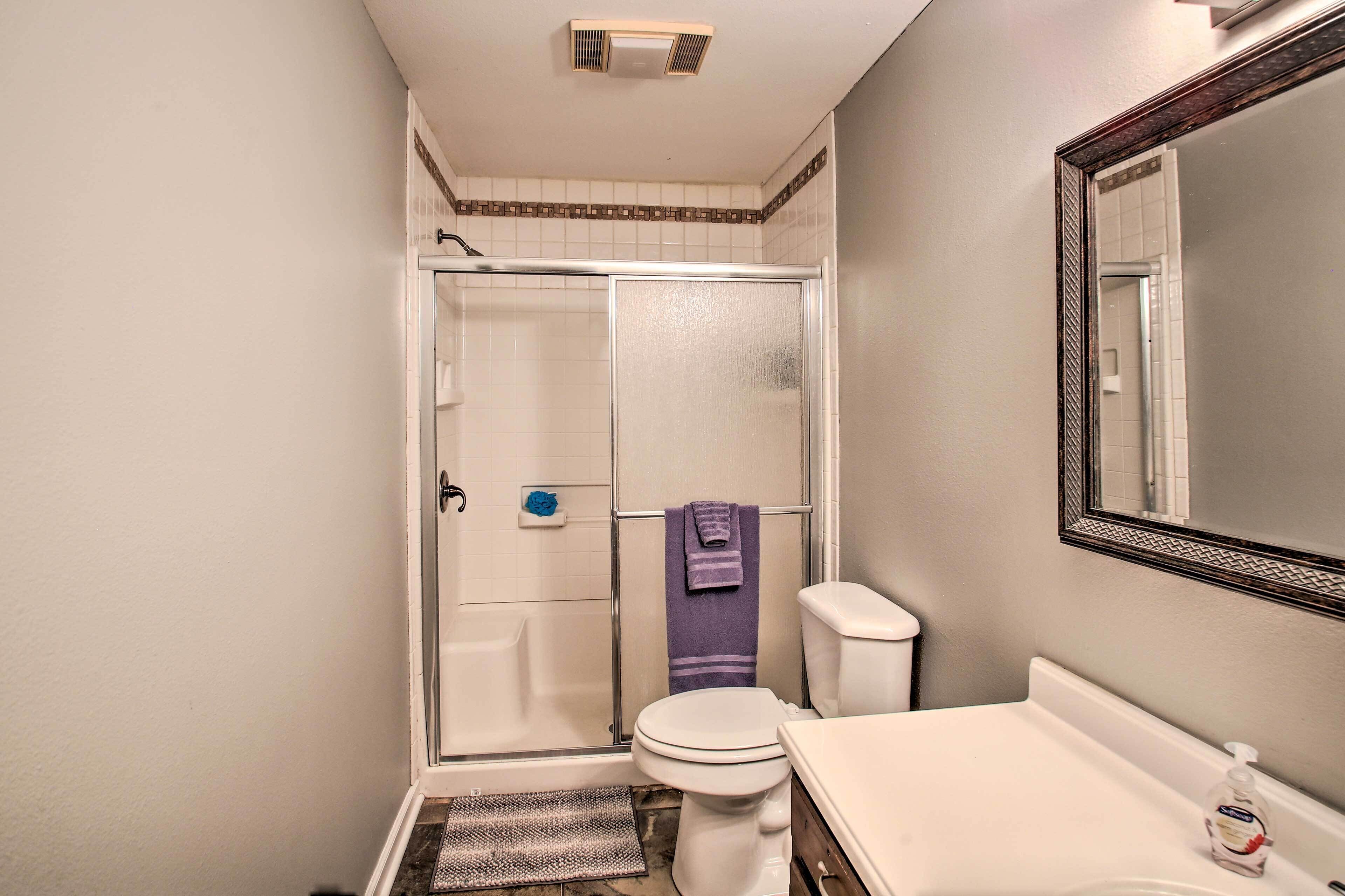 A compact bathroom with a shower, toilet, and sink.