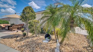 A patio with outdoor furniture, a palm tree, and a decorative bird sculpture. - ~ 1 Mi to Golf: Home w/ Patio in The Villages! (The Villages)