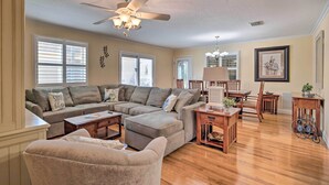 A living room with a sectional sofa, a coffee table, a dining table with chairs, and a ceiling fan. - ~ 1 Mi to Golf: Home w/ Patio in The Villages! (The Villages)