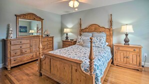 A bedroom with a wooden bed, nightstands, a dresser, and a ceiling fan. - ~ 1 Mi to Golf: Home w/ Patio in The Villages! (The Villages)