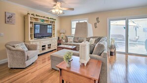 A living room with a TV, sofa, and coffee table. - ~ 1 Mi to Golf: Home w/ Patio in The Villages! (The Villages)