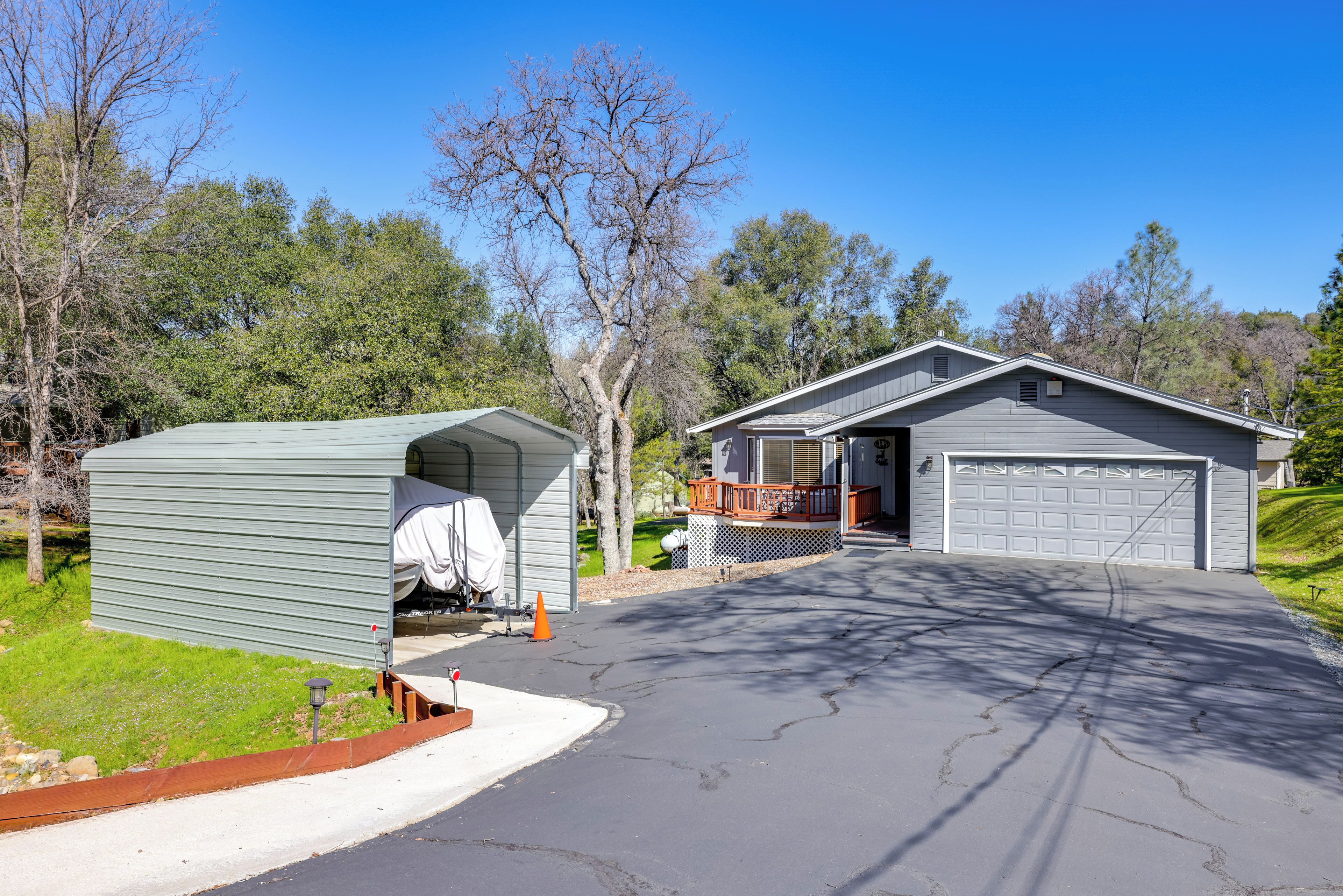 Ein bungalow mit Garage, überdachter Terrasse und Auffahrt.