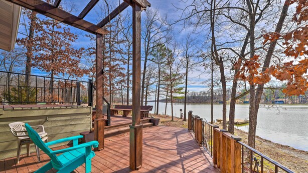 A wooden deck with a view of a lake, surrounded by trees with autumn leaves. - Lakefront Vacation Rental w/ Deck & 2 Docks! (Williford)