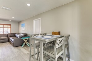 A dining area with a table set for four, a sofa, and a window with blinds. - Private Hot Tub: Breezy Seminole Stay! (Seminole)