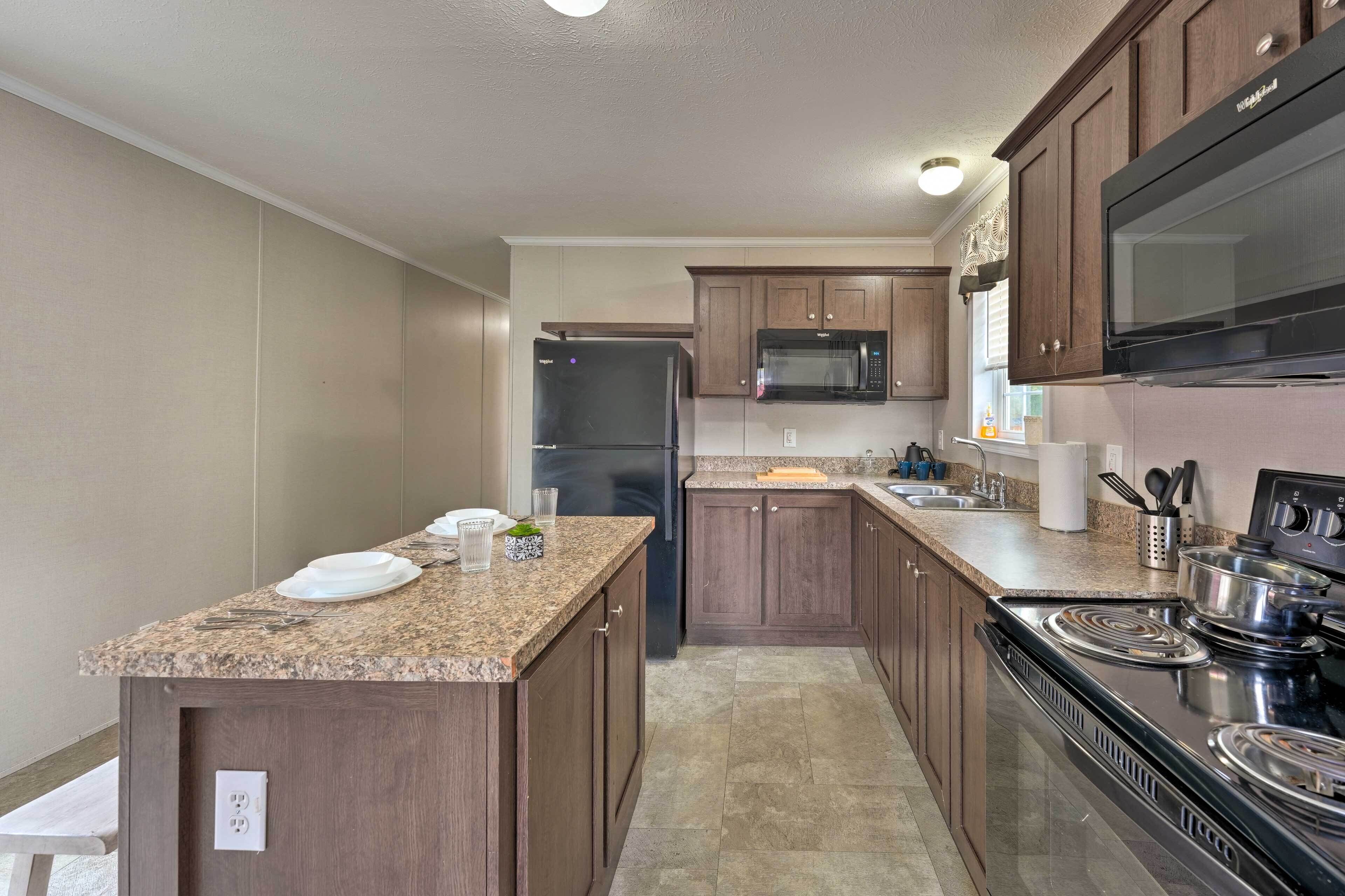 A modern kitchen with granite countertops, stainless steel appliances, and wooden cabinets.