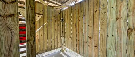 Una estructura de madera con techo inclinado y piso de concreto.