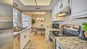 A modern kitchen with white cabinets, a stainless steel refrigerator, a granite countertop, and a built-in oven. - 8 Mi to Beaches: Bradenton Home w/ Poolside Oasis! (Bradenton)