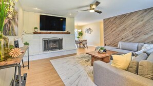 A living room with a fireplace, a sofa, a coffee table, and a dining area with a table and chairs. - 8 Mi to Beaches: Bradenton Home w/ Poolside Oasis! (Bradenton)