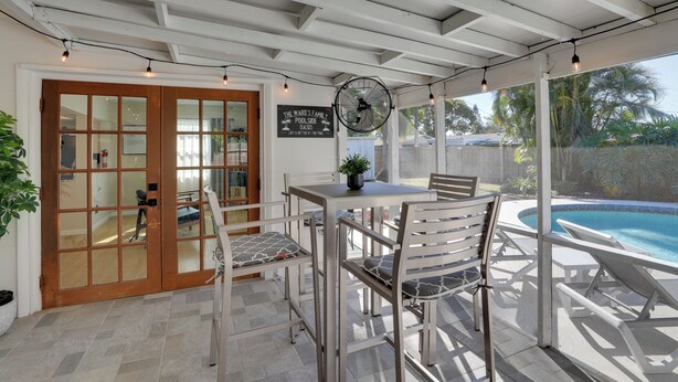 A covered patio with a pool, a table with chairs, and a fan. - 8 Mi to Beaches: Bradenton Home w/ Poolside Oasis! (Bradenton)