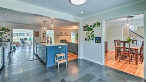 A spacious kitchen with a central island, dark flooring, and modern lighting fixtures. - Peaceful Southern Pines Home w/ Pool + Yard! (Southern Pines)