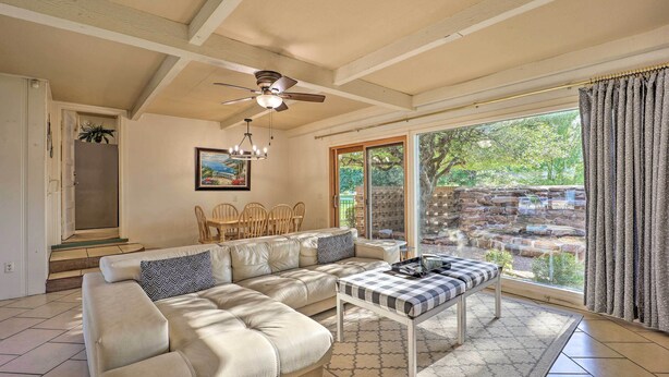 A spacious living room with a sectional sofa, a dining table, and a ceiling fan. - 10 Mi to Grand Lake: Home w/ Game Room in Jay! (Jay)