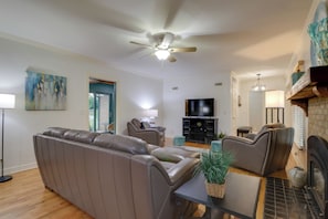 A modern living room with a leather sofa, a coffee table, and a fireplace. - 10 Mi to Grand Lake: Home w/ Game Room in Jay! (Jay)