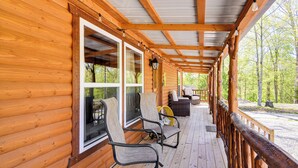 A wooden cabin with a covered porch, large windows, and outdoor seating. - Somerset Cabin, Close to Lake Access! (Somerset)