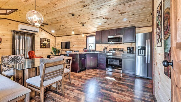 A wooden cabin interior with a dining area, kitchen, and living space. - Somerset Cabin, Close to Lake Access! (Somerset)