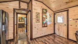 A wooden interior with a kitchen area, wooden flooring, and a door leading to another room. - Somerset Cabin, Close to Lake Access! (Somerset)