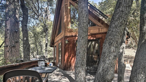 A wooden cabin with a deck, surrounded by tall trees. - Updated 'tree House' Pine Mtn Club Cabin by Trails (Pine Mountain Club)