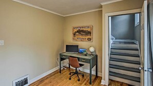 Una habitación con un escritorio, una silla y un cuadro en la pared.