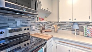 A modern kitchen with stainless steel appliances, white cabinetry, and a tiled backsplash. - Couples Getaway in North End Boise - Walk to Dtwn (Boise)