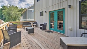 Une terrasse dotée de mobilier d’extérieur, d’une porte-fenêtre coulissante et offrant une vue sur les environs.