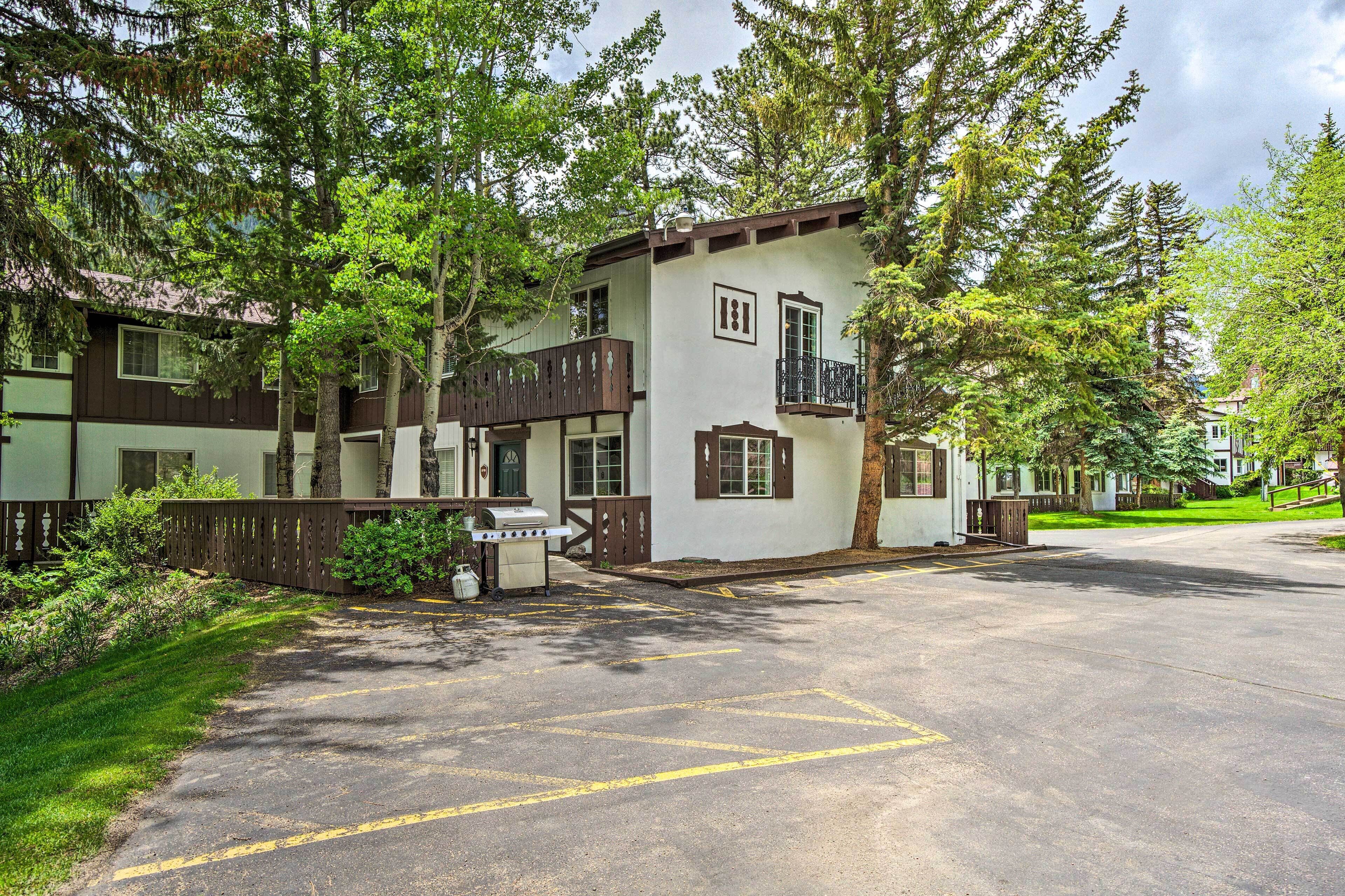 A two-story building with a balcony, a garage, and a well-maintained lawn.