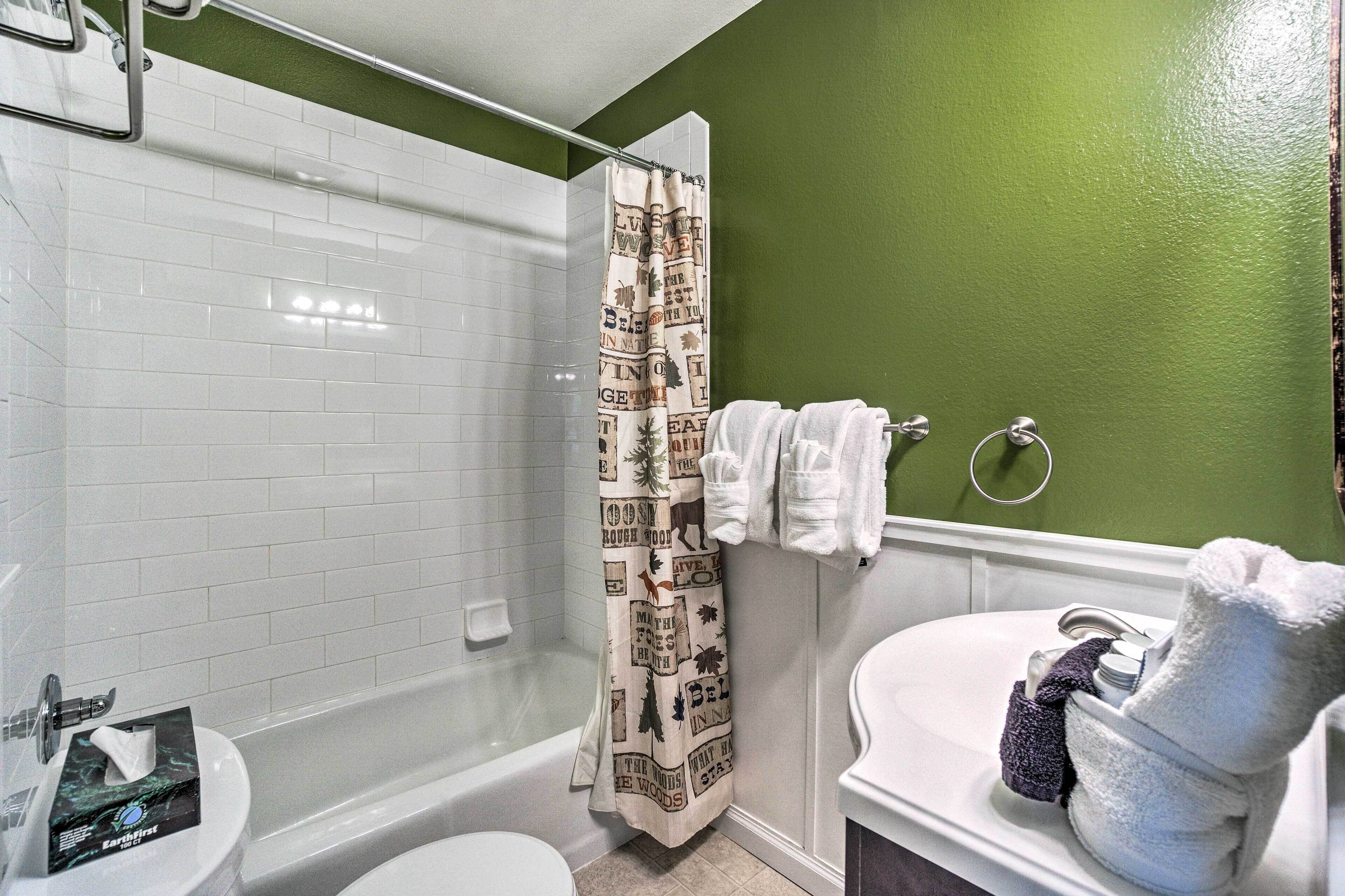 A bathroom with a shower, toilet, and sink.