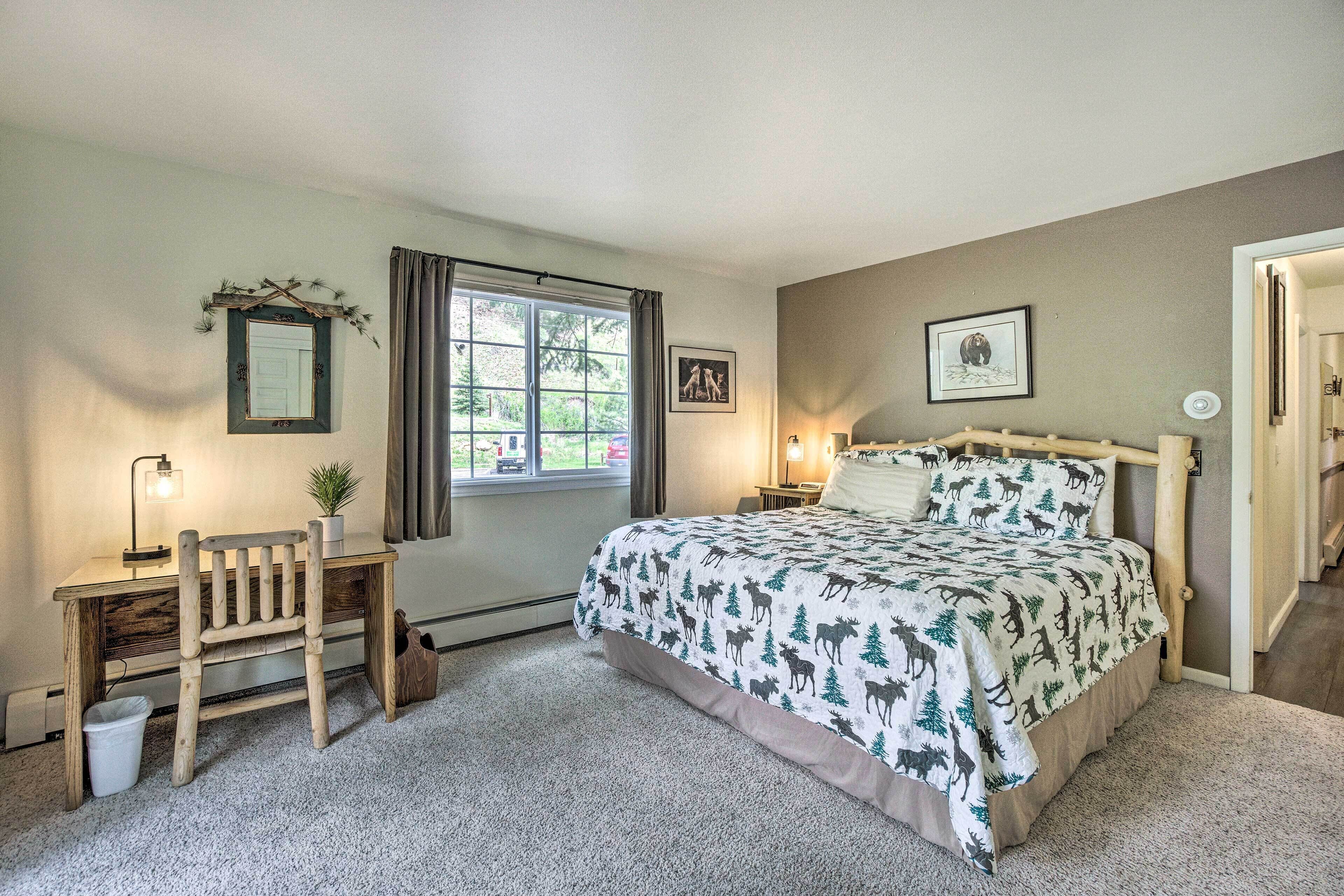 Une chambre à coucher avec un lit, un bureau, une chaise, une fenêtre et une porte.