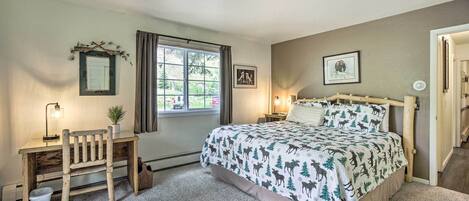 Ein Schlafzimmer mit einem Bett, einem Schreibtisch, einem Stuhl, einem Fenster und einer Tür.