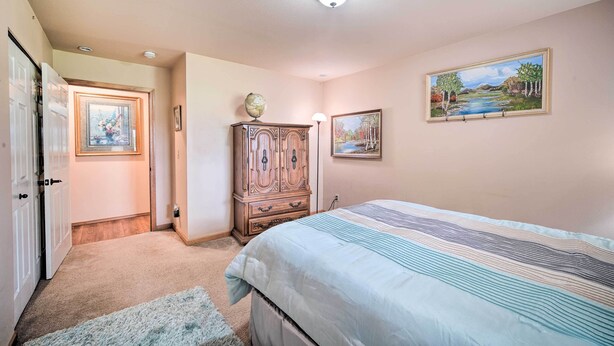 A bedroom with a bed, a dresser, a globe, and two framed pictures on the wall. - Upscale Home w/ Indoor Sauna on Sunset Pond! (Ferndale)