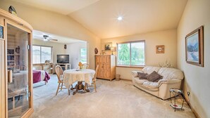 A cozy living room with a dining area, a television, and a large window with blinds. - Upscale Home w/ Indoor Sauna on Sunset Pond! (Ferndale)