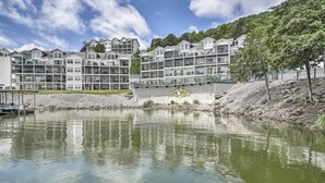 Un hôtel à plusieurs étages, doté de balcons, donnant sur un plan d’eau et portant l’inscription « Cedar Heights ».