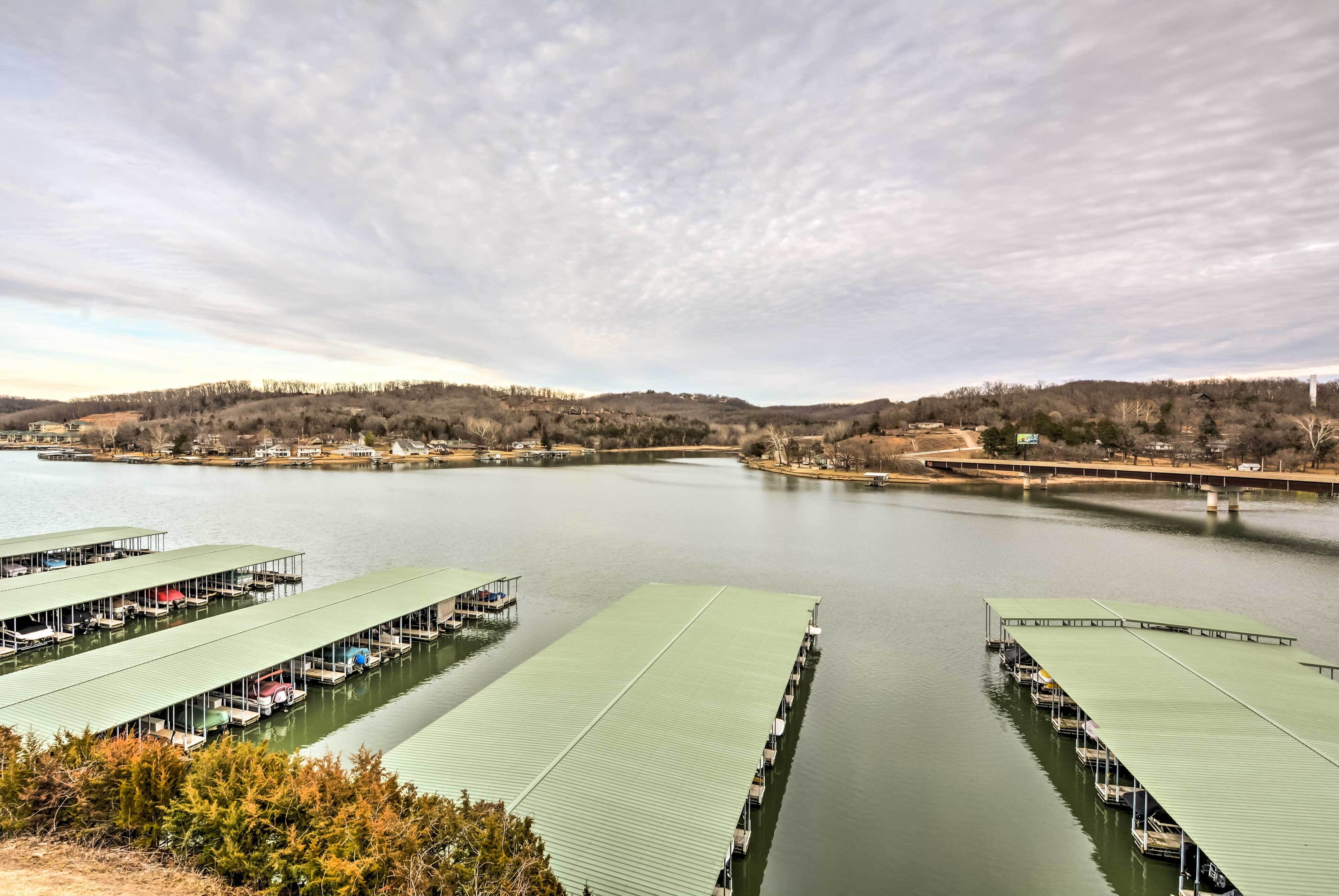 A marina with multiple docked boats and green-roofed structures.