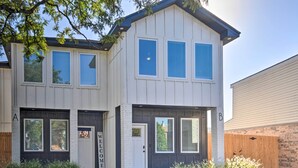 En tvåvånings bostadsbyggnad med ett garage, en ytterdörr och en välkomstskylt.