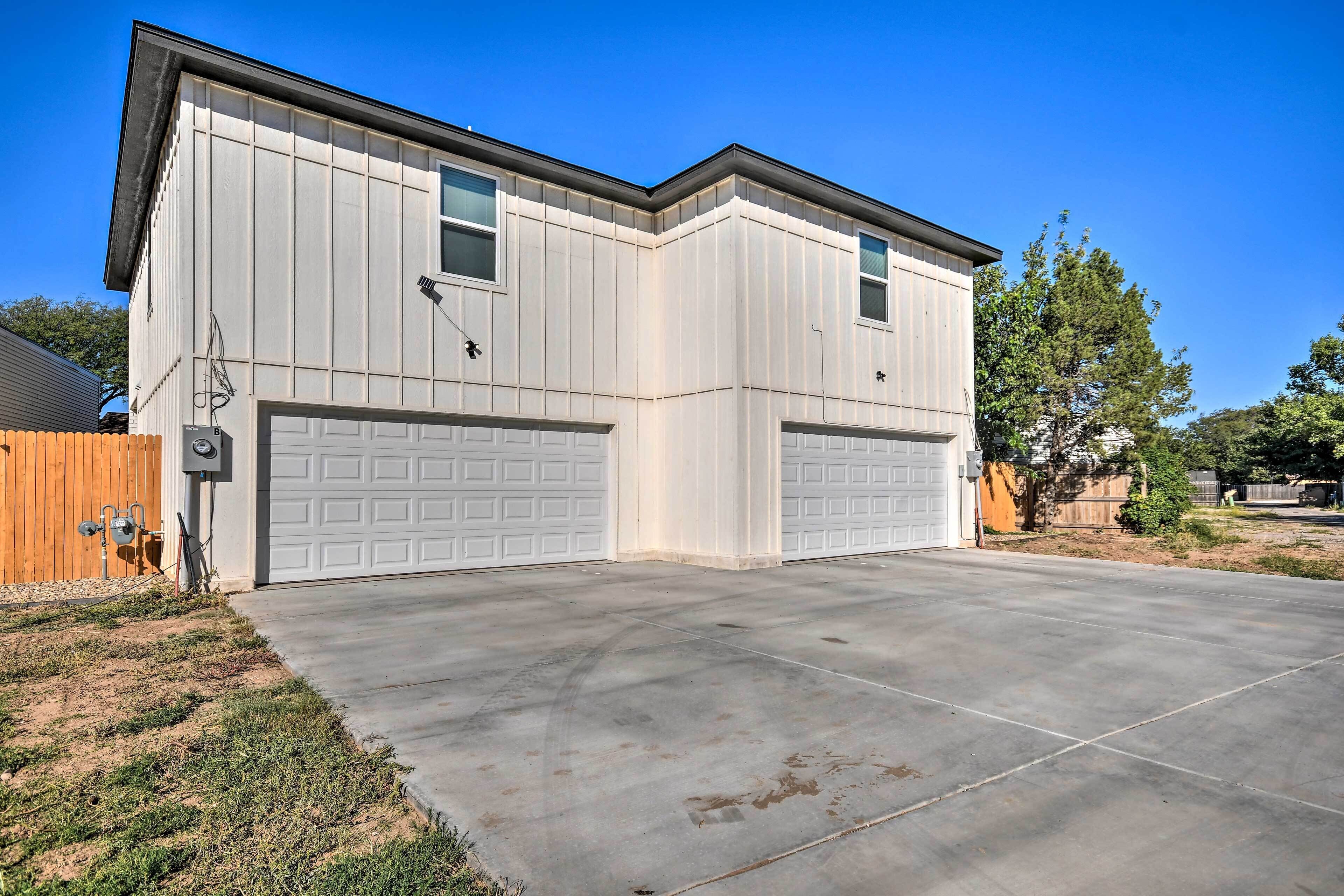A two-car garage with a concrete driveway and a wooden fence.