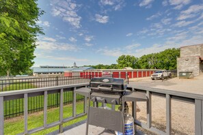 Een barbecue op een terras, met uitzicht op een gebouw op de achtergrond.