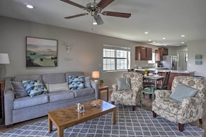 A spacious living room with a gray sofa, patterned armchairs, and a wooden coffee table. A ceiling fan and recessed lighting are visible. - < 1 Mi to Branson Strip: Condo on Golf Course! (Branson)