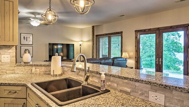 A kitchen with granite countertops, a double sink, and pendant lighting. - Beaver Lake Retreat w/ Lake Access & Fire Pit! (Garfield)