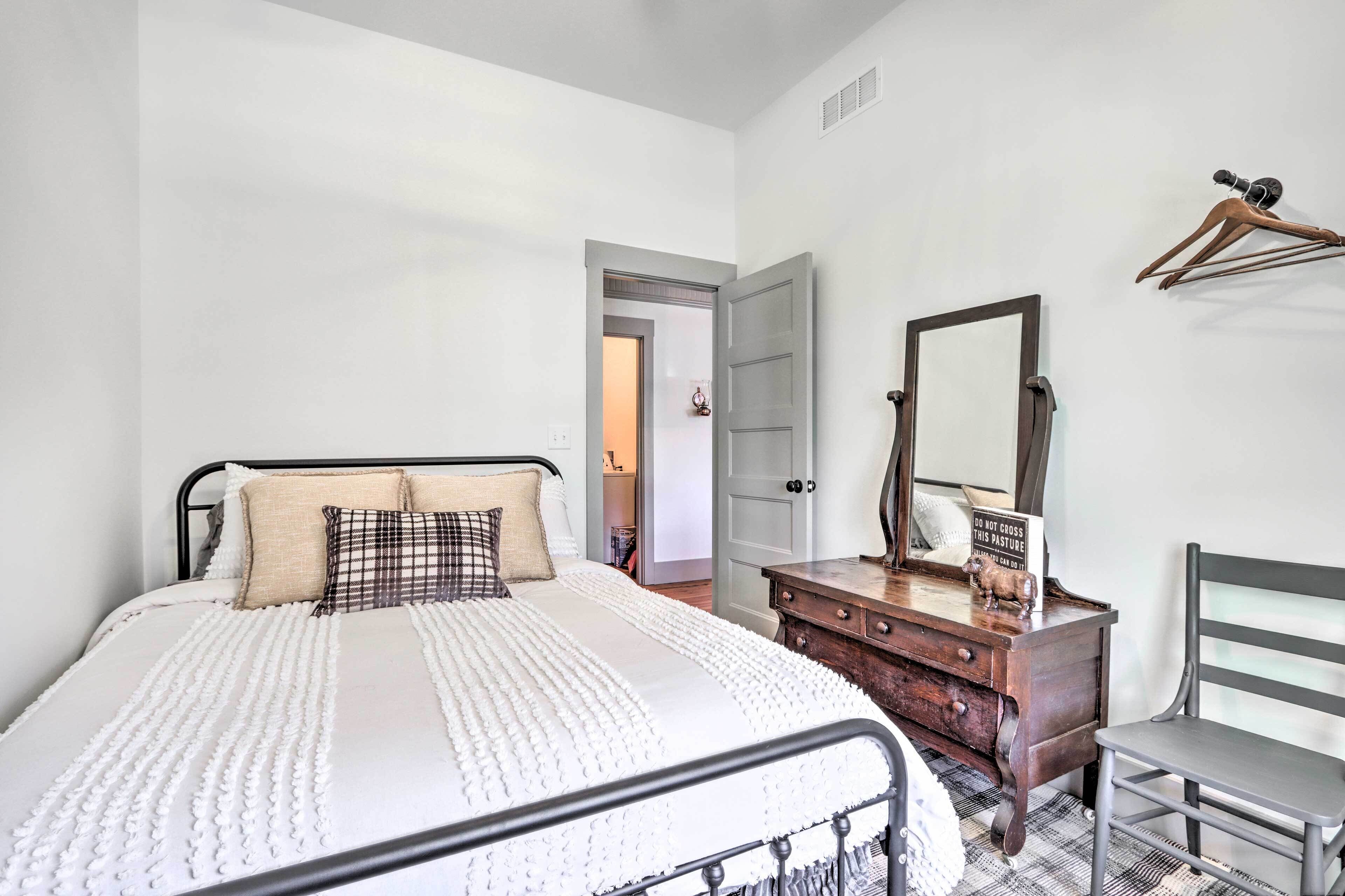 Ein Schlafzimmer mit Bett, Schminktisch, Spiegel und Stuhl.
