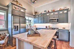 Una cocina moderna con armarios grises, electrodomésticos de acero inoxidable y una isla de madera.
