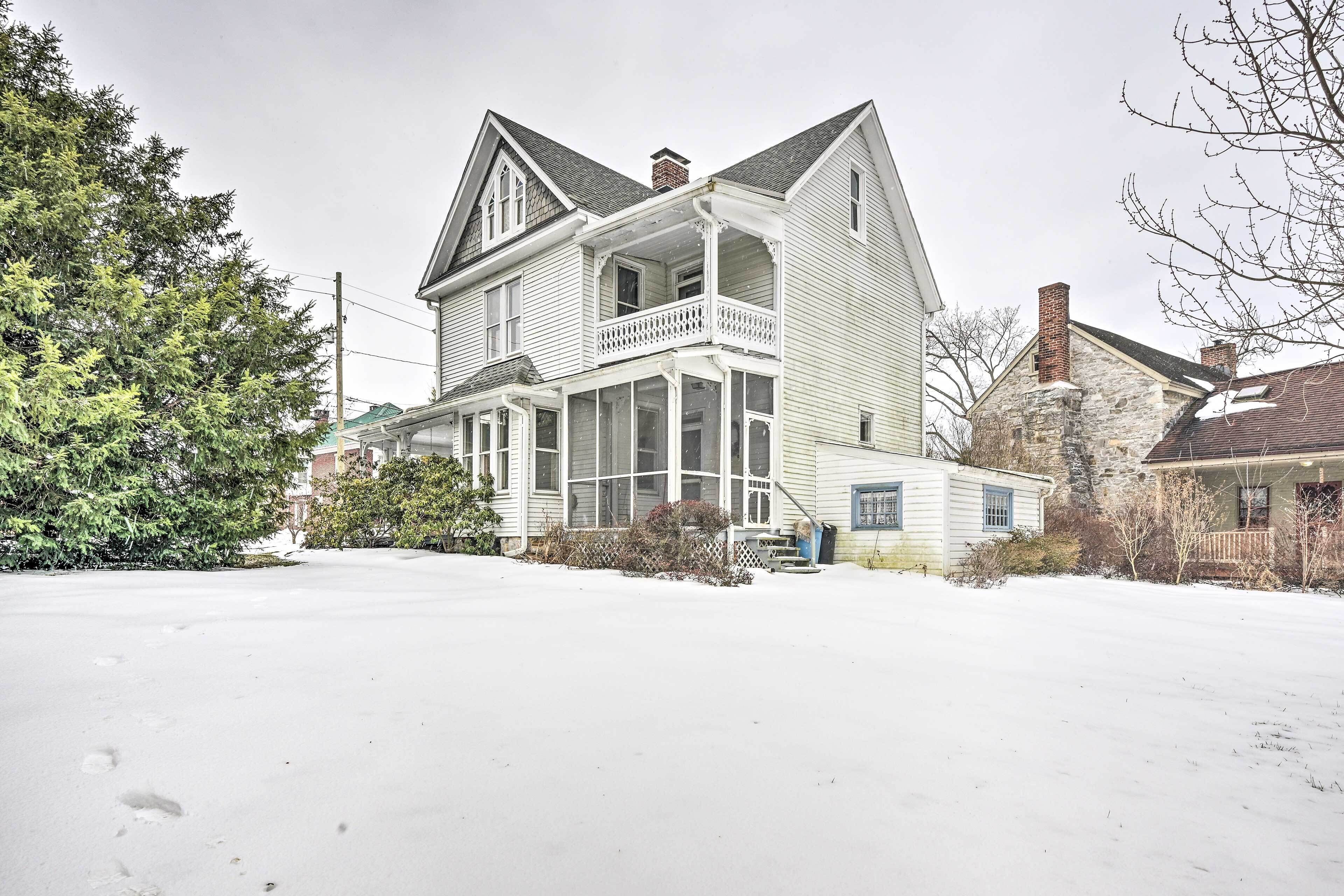 A two-story house with a porch and a chimney.