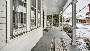 A porch with white columns, a black and white rug, and a view of a snowy street. - Spacious Getaway: 7 Mi to Whitetail Slopes! (Mercersburg)