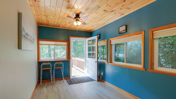 A room with wooden ceiling, large windows, and a door leading outside. - Harpers Ferry Cabin - Walk to Private Lake! (Harpers Ferry)
